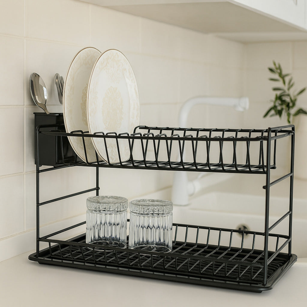 Black two-tier dish rack holding white plates and glasses on a light worktop