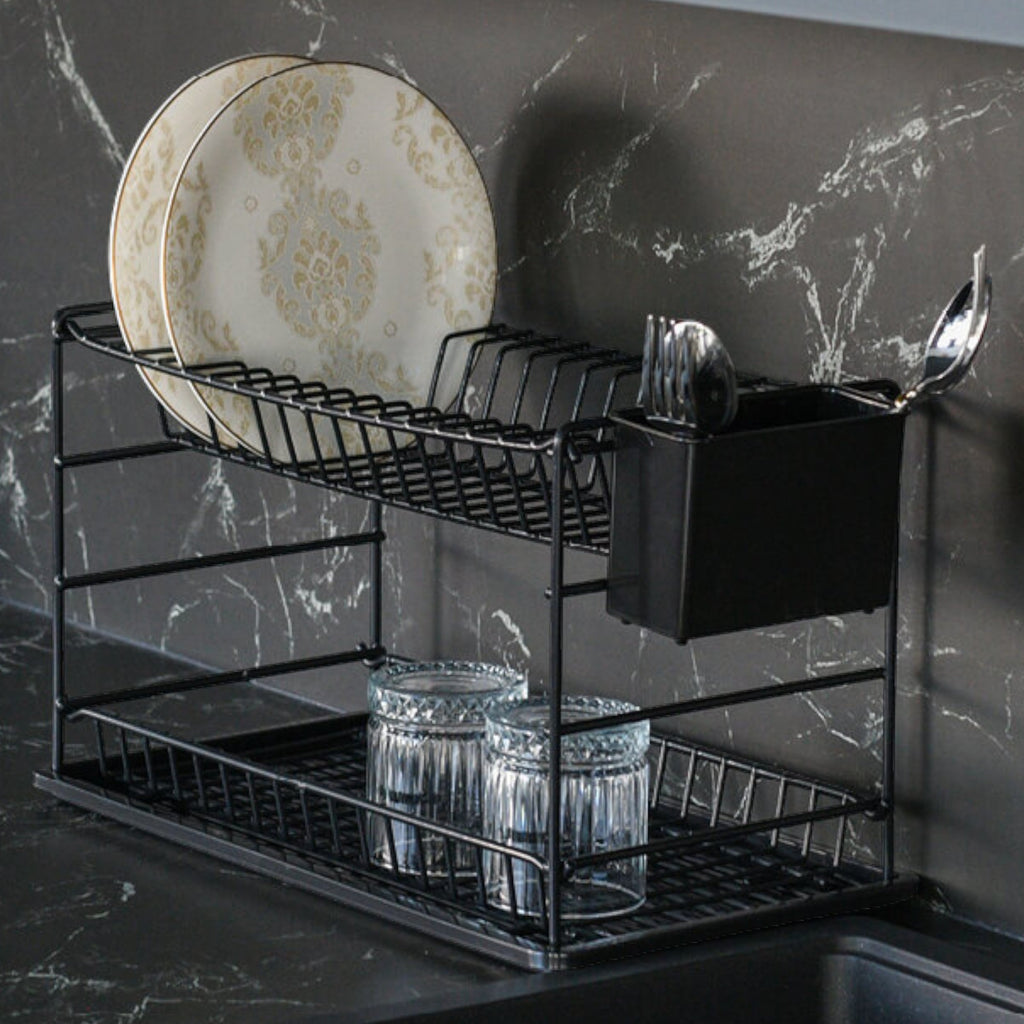 Close-up of a black two-tier dish rack holding plates, glasses and cutlery