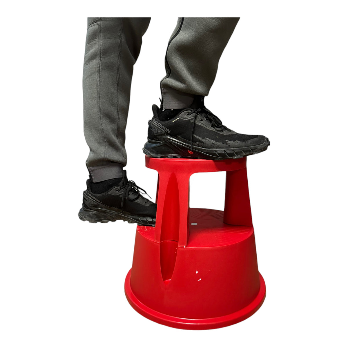 Person using the lower and upper steps of a red kick stool