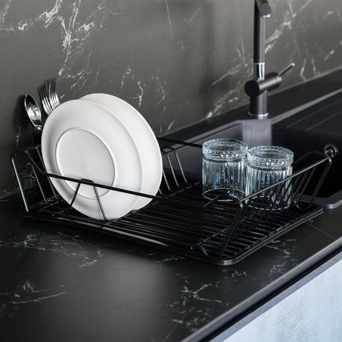 TheOwnas large black metal dish drainer rack with a drip tray and cutlery holder on a modern kitchen countertop