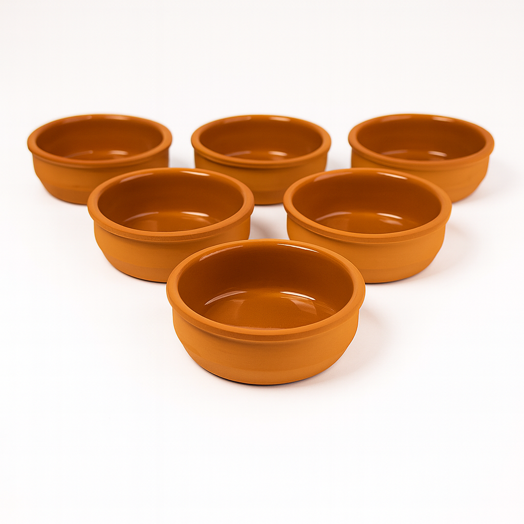 Set of six empty glazed terracotta tapas dishes arranged in rows