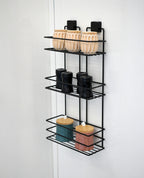 TheOwnas 3-tier black rectangular shower caddy mounted on a white wall with various bathroom storage containers